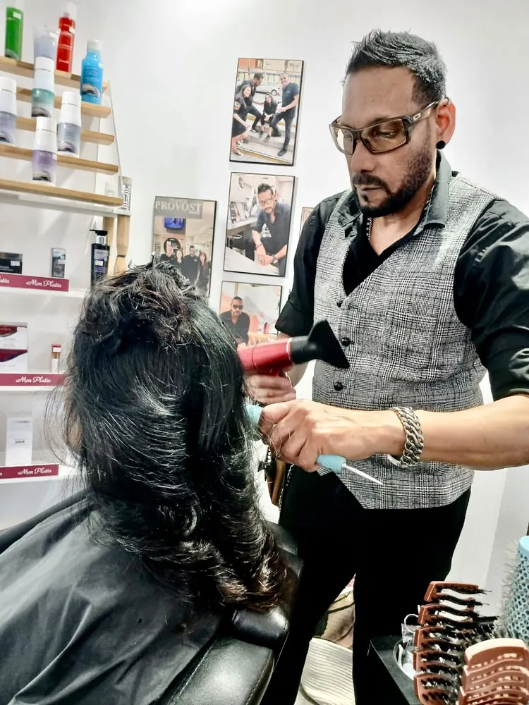 Kris blow-drying a client's hair in the salon